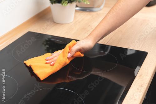 Woman cleaning induction stove photo