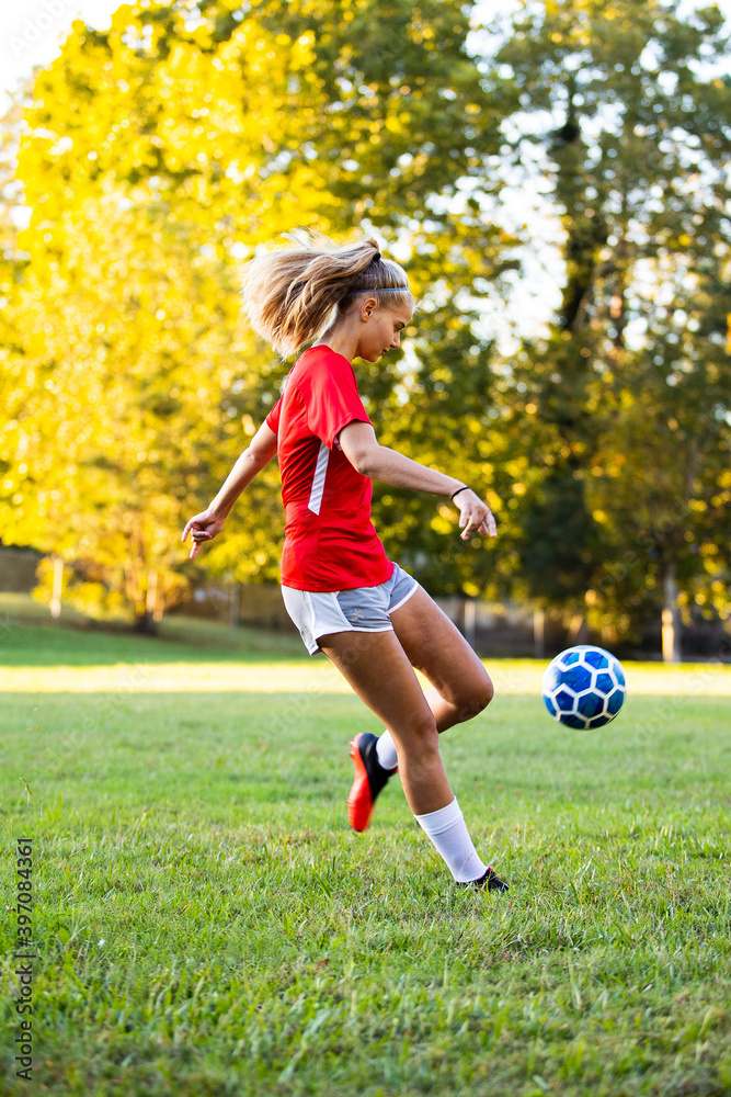 Teen girl soccer player kicking ball Teen girl soccer player kicking ball