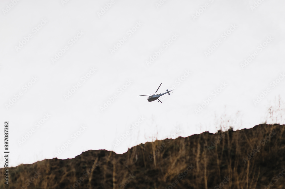 A military helicopter flies in the sky in cloudy weather. A military helicopter flies in the sky in cloudy weather.