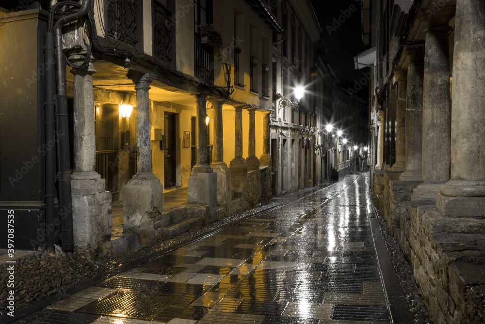 Calle medieval típica de Avilés de noche y mojada
