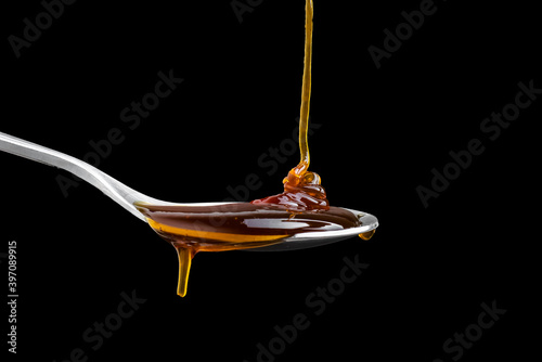 Close up Golden sweet honey dripping from spoon