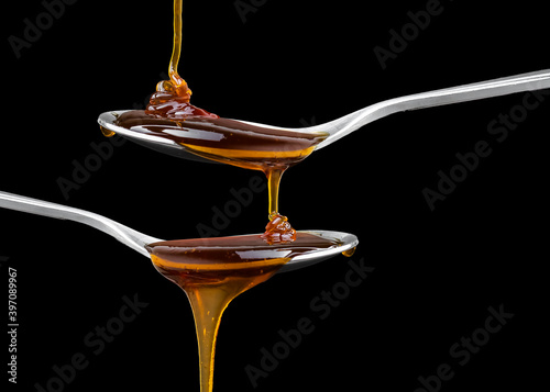 Close up Golden sweet honey dripping from spoon