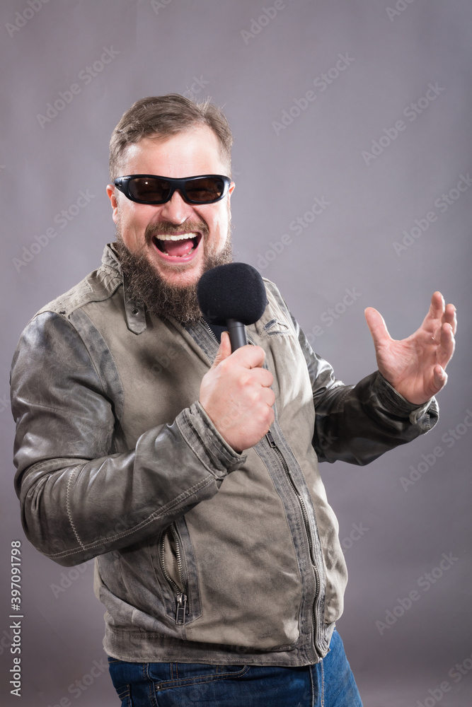 Bearded emotional rock singer with microphone studio portrait. Bearded emotional rock singer with microphone studio portrait.