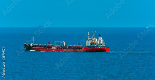 A small, old tanker ship at sea approaching the Singapore Straits in Asia in summertime
