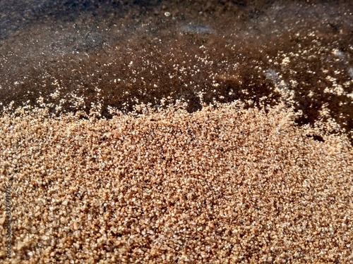 close-up of the junction of the sand and ice line on the river