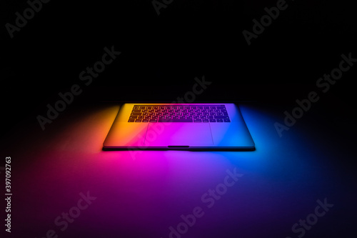 Half opened MacBook illuminated with gradient view front