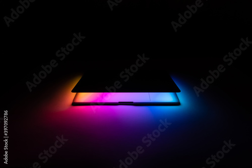 Opened MacBook illuminated with gradient view front photo