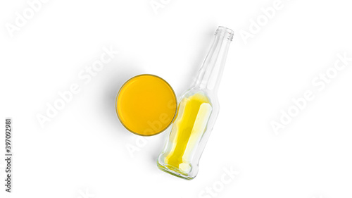 A bottle and glass with yellow drink on a white background. High quality photo