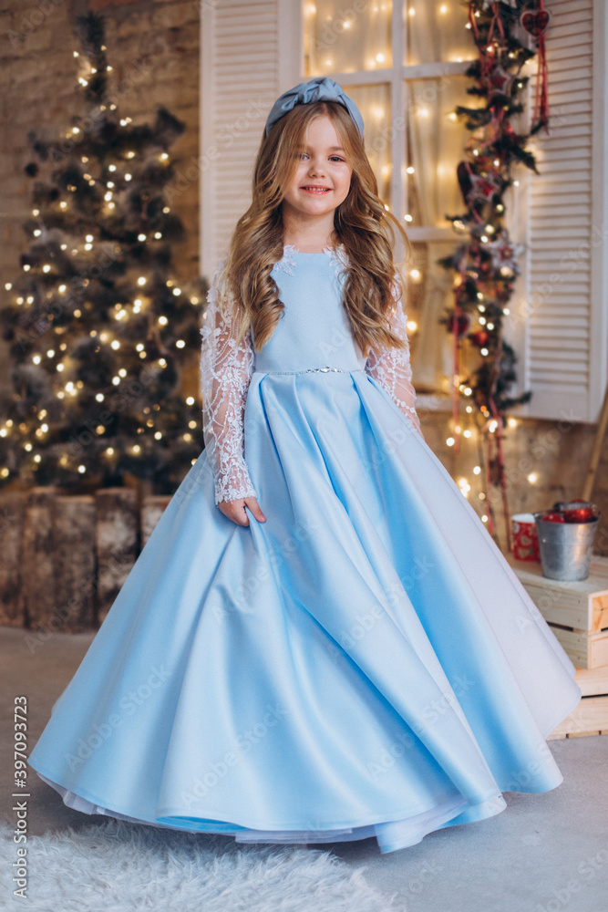 Little cute happy adorable girl in elegant fashion dress in christmas decorations. Christmas holidays, celebaration concept Little cute happy adorable girl in elegant fashion dress in christmas decorations. Christmas holidays, celebaration concept