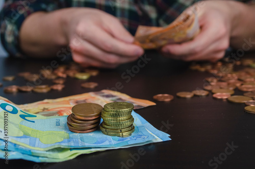manos de hombre contando dinero, monedas y billetes