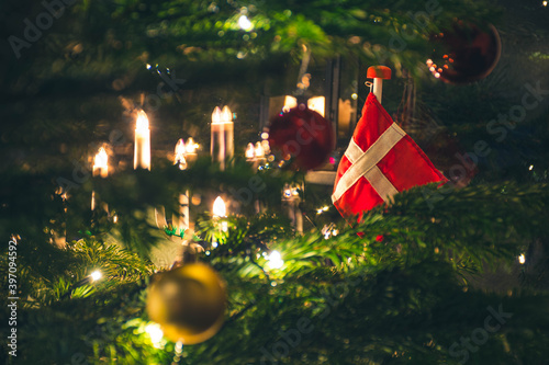 Photography A beautifully decorated Christmas tree adorned with traditional Danish flags, glowing candles, and festive ornaments