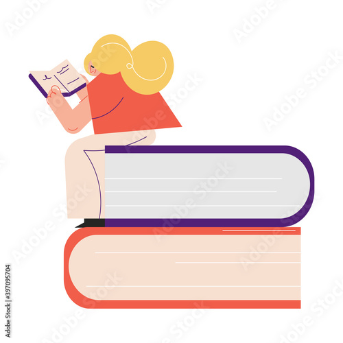 Happy young woman sitting on books heap and reading book in library