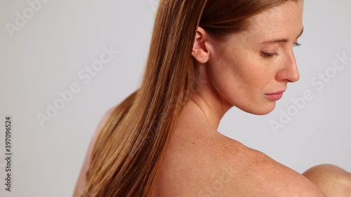 Rotating shot of nude woman looking over her shoulder