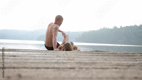 Affectionate couple on edge of dock at lake photo