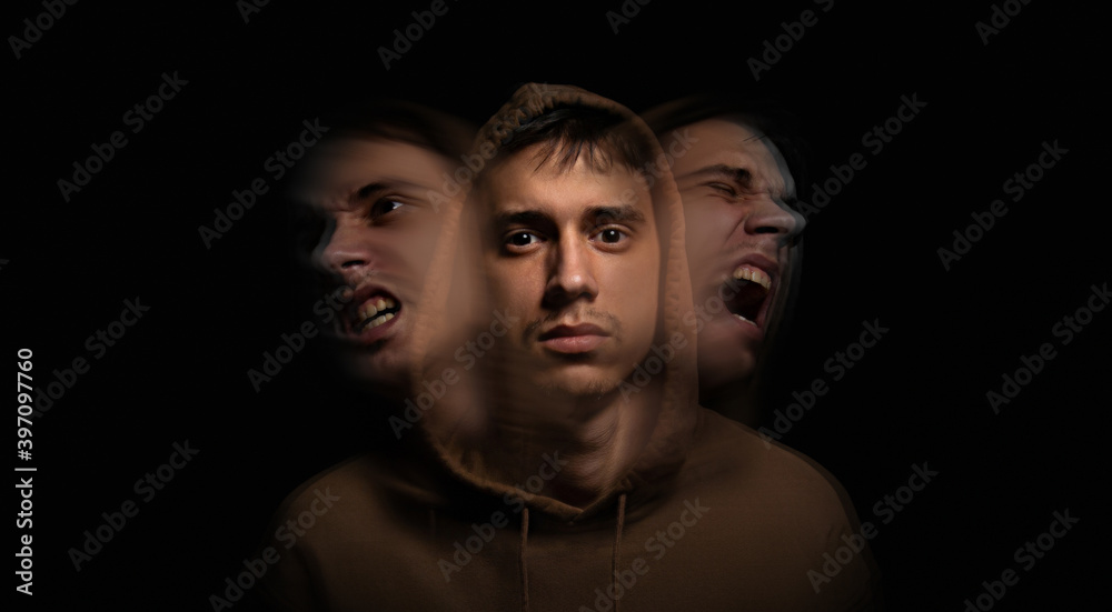 Art portrait on the topic of self-isolation. Split personality. Young guy on a dark background. Self-isolation affects a person. Art portrait on the topic of self-isolation. Split personality. Young guy on a dark background. Self-isolation affects a person.