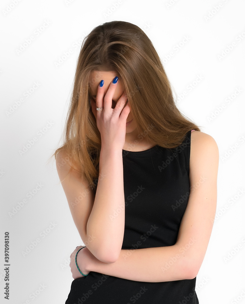 Upset girl covered her face and standing on a white background Upset girl covered her face and standing on a white background
