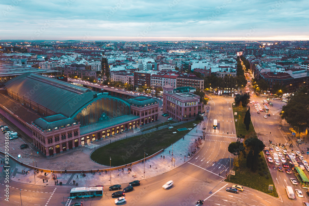 look from above view aerial drone shot Spain Madrid capital cloudy evening buildings lamps traffic Estación del Arte