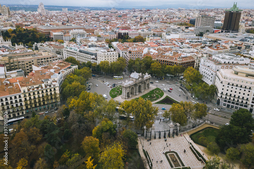 look from above view aerial drone shot Spain Madrid capital cloudy buildings traffic Puerta de Alcalá