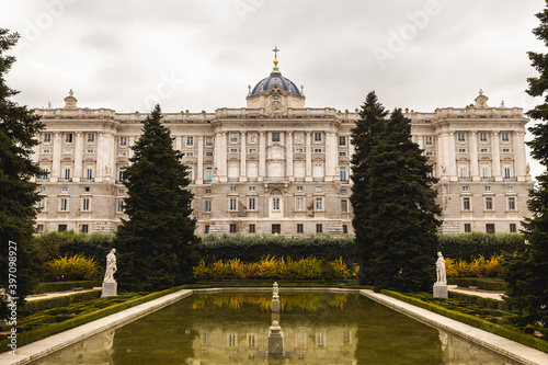 royal garden in Spain Madrid capital green bush and shaped trees pond reflection cloudy day Plaza de la Armería