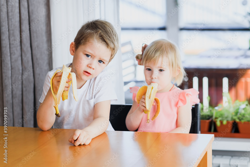 A girl and a boy eating a banana. A girl and a boy eating a banana.