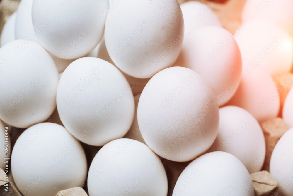 Chicken eggs in carton box on table. White eggs closeup. Rustic food concept. Chicken eggs in carton box on table. White eggs closeup. Rustic food concept.