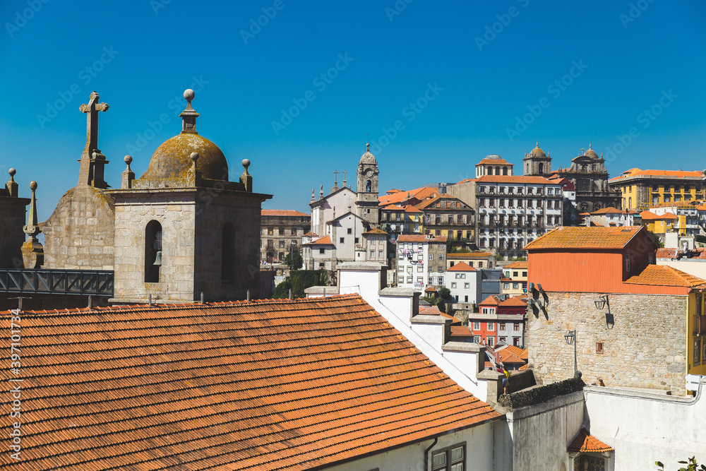 Porto Portugal old houses building colorful roofs rooftops orange red tower crossblue sky daylight sunny