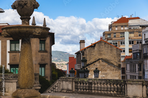 Bigo Spain Vigo buildings with a beach in the background sunny day old with a non functional fountain  photo