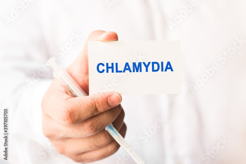 Word chlamydia on a white background with a syringe in hand. Medicine concept