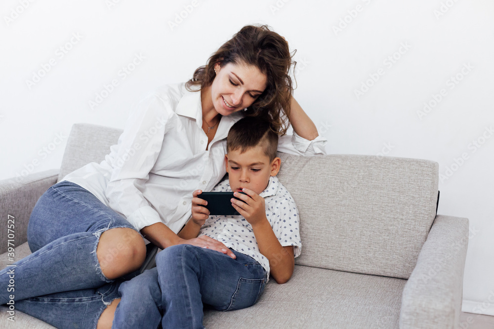 Mom and son play smartphone games on the couch