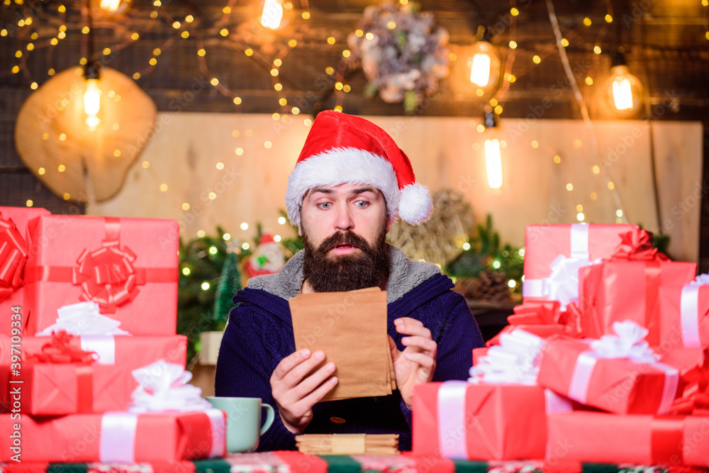 Hipster prepared gifts for family. Generous new year. Fulfill cherished dreams. Lot of gifts. Wrapped gifts with ribbons and bows. Happy winter holidays. Man bearded santa claus hat reading letters Hipster prepared gifts for family. Generous new year. Fulfill cherished dreams. Lot of gifts. Wrapped gifts with ribbons and bows. Happy winter holidays. Man bearded santa claus hat reading letters
