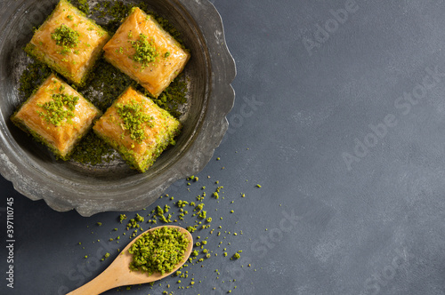 Traditional turkish dessert antep baklava with pistachio on rustic table, ramadan or holiday desserts concept