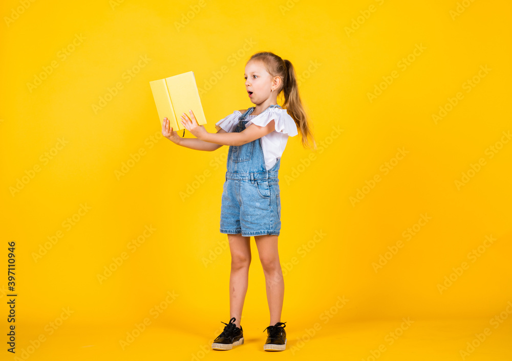 Dedicated to studying. notebook for making notes. childrens literature. back to school. happy childhood. cute child on yellow background. education. beautiful teen girl with books. kid like reading Dedicated to studying. notebook for making notes. childrens literature. back to school. happy childhood. cute child on yellow background. education. beautiful teen girl with books. kid like reading