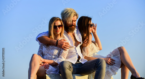 Having rest. Young and free. summer relax at sunset. beauty and fashion. Fashion people look casual in summer outfit. Group of people. love and friendship concept. brutal man embrace two sexy women © be free