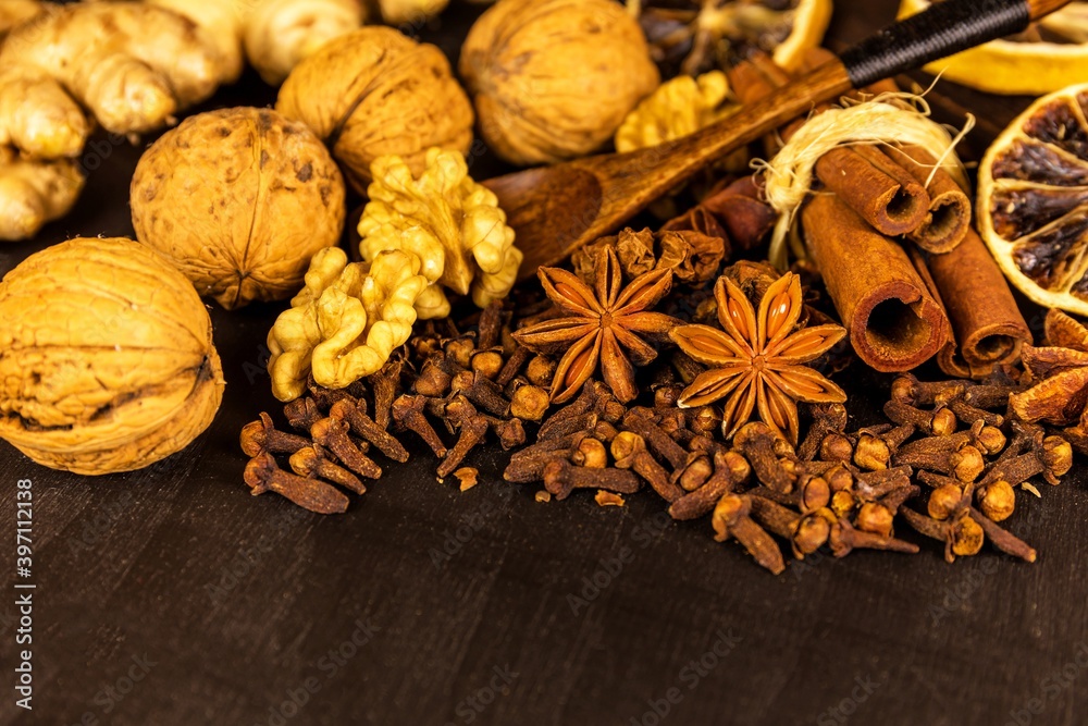 Traditional Christmas spices - Star anise with cinnamon and cloves and wallnuts on black rustic wooden background. Medicinal spices. Traditional Christmas spices - Star anise with cinnamon and cloves and wallnuts on black rustic wooden background. Medicinal spices.