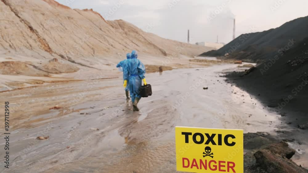 Backview footage of ecology experts in special protective costumes