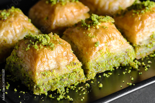 Traditional turkish dessert antep baklava with pistachio on rustic table,  ramadan or holiday desserts concept photo