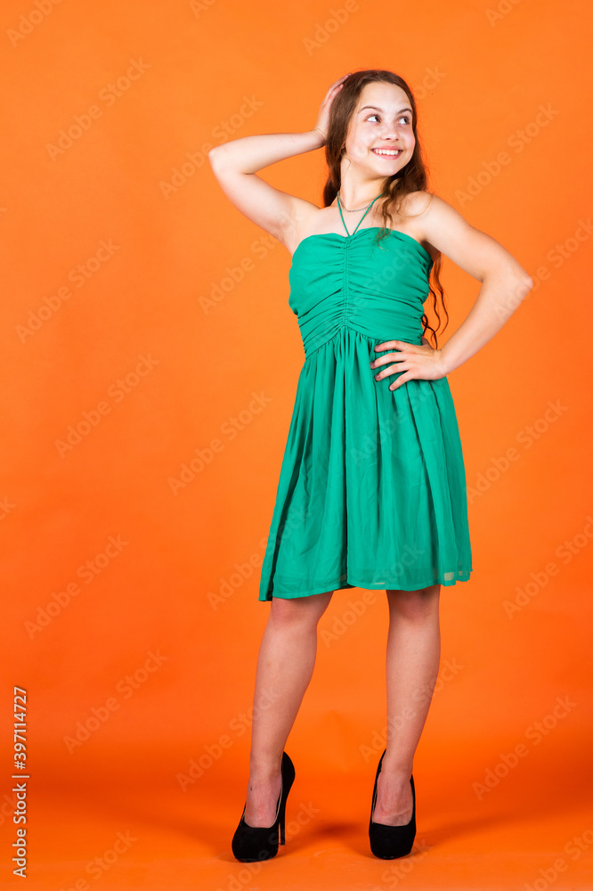 Fototapeta premium Glamour fashion model. stylish cute child posing in studio. Summer and spring fashion concept. fashion model posing. her trendy style. elegant formal look. fashion child baby girl kid in dress