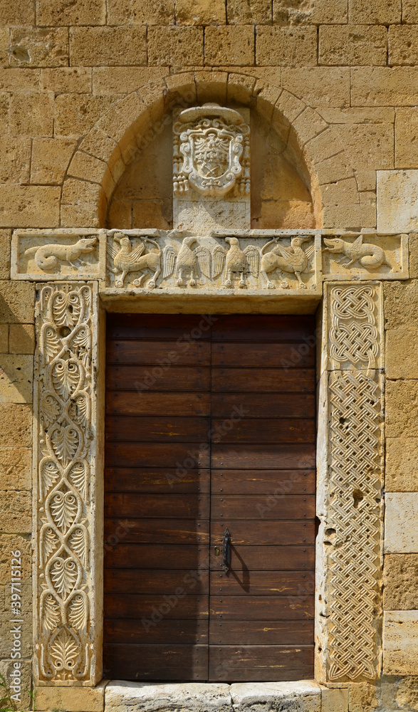 Ancient wooden doors with ornamental frame, Abbey of Sant'Antimo near Montalcino