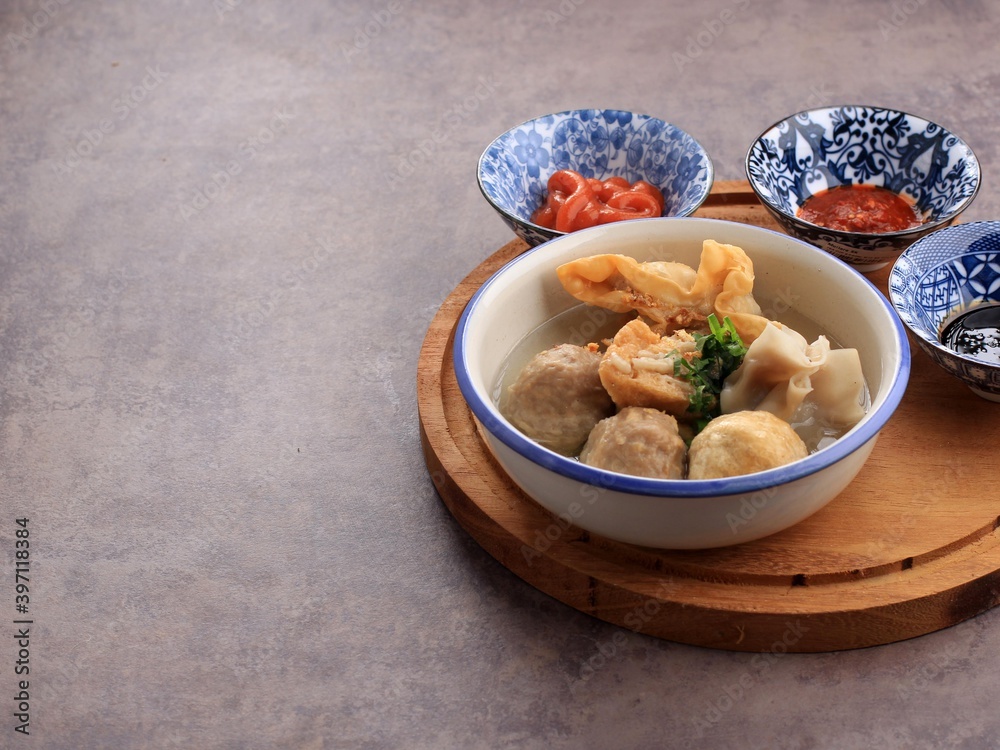 Bakso Malang, Meatball Soup with Various Side Dish like Tofu Fried Shiumay, or Bakso Goreng. Served on the Table with Sambal, Soysauce, and Tomato Sauce. Selected Focus