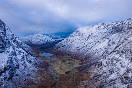 an aerial view of Glen Coe in winter near rannoch moor in the argyll region of the highlands of scotland showing snow dusting on the mountains and munros