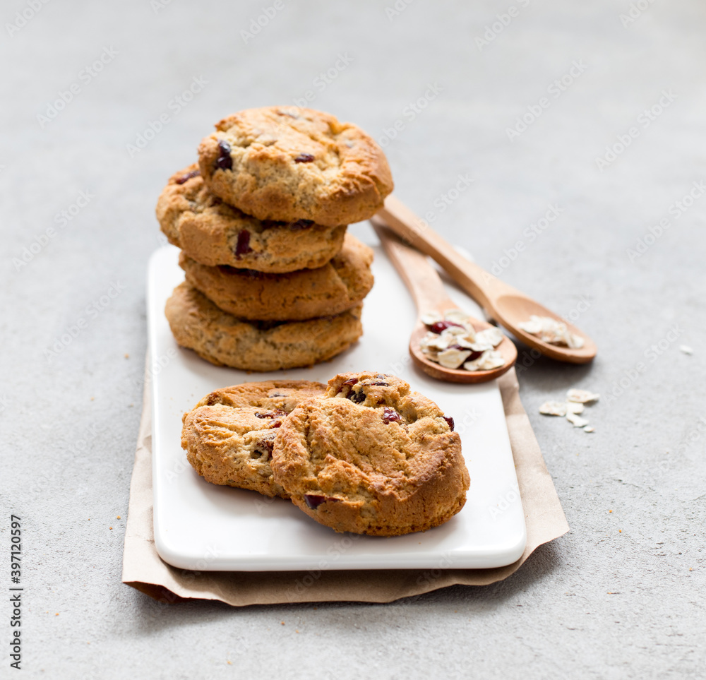 Breakfast oatmeal cookies with dried cranberries on a tray on a light gray background