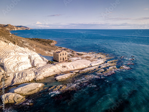 Fototapeta Naklejka Na Ścianę i Meble -  Punta Bianca, Agrigento in Sicily Italy White beach with old ruins of an abandoned stone house on white cliffs. Sicilia Italy, couple on vacation in Italy