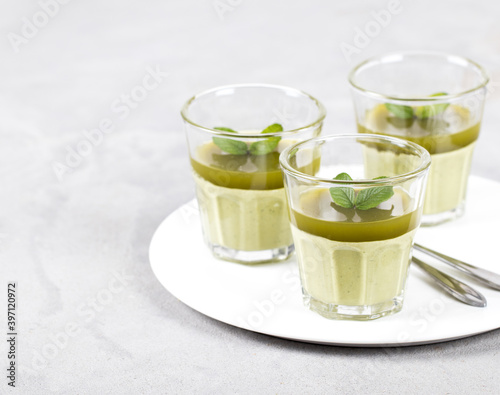 Italian Panna Cotta creamy green matcha tea in a glass on a plate on a light background