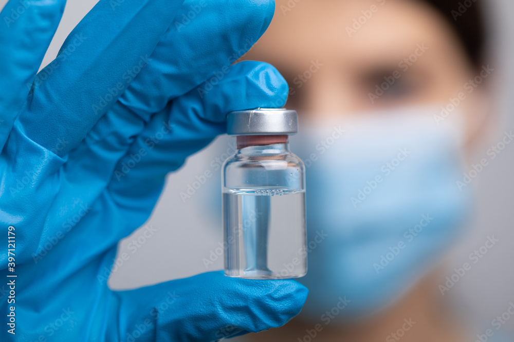 Doctor scientist with protective gloves and face mask holding vaccine medicine dose Doctor scientist with protective gloves and face mask holding vaccine medicine dose