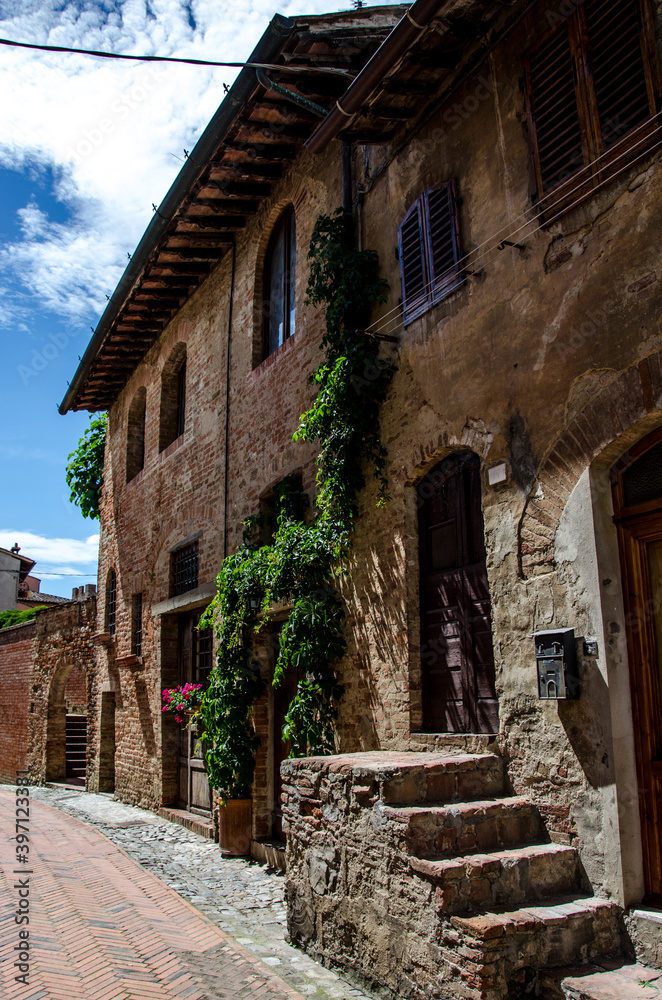 View of an alley with houses of the ancient stone made medieval town, Italy. No people.