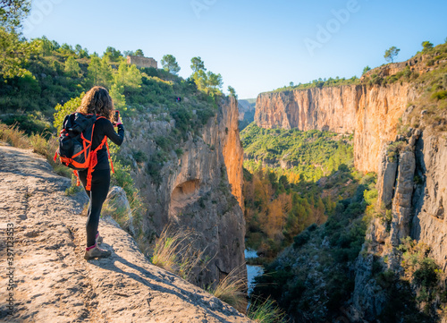 Joven mujer fotografiando el inmenso cañón  del río Turia a su paso por Chulilla (València) photo