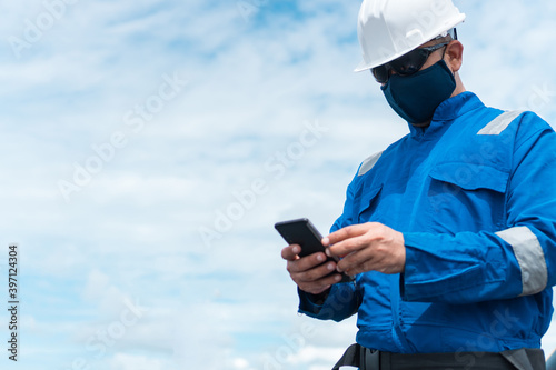 Marine seaman or bosun on deck of vessel or ship. He is speaking on the mobile cell phone