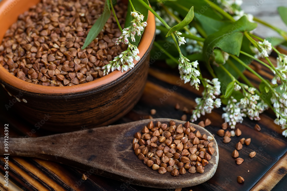 Dry buckwheat in an ecological wooden spoon. Food vegans gluten-free diet. Dry buckwheat in an ecological wooden spoon. Food vegans gluten-free diet.