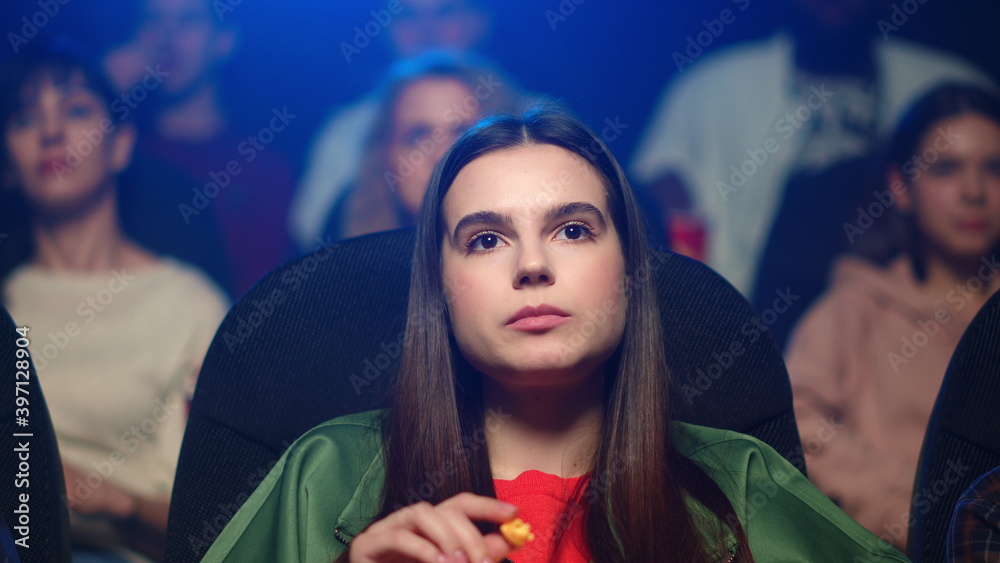 Shocked woman sprinkling popcorn after scary scene in movie theater. Shocked woman sprinkling popcorn after scary scene in movie theater.