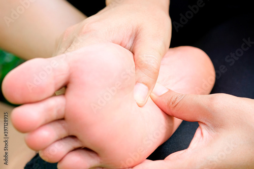 Foot Pain ,young man sitting on the bed at home,  he holding  feet press massage . Concepts of pain and health therapy.